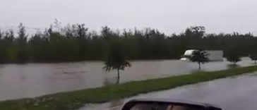 A truck driver driving through dangerously flooded road - Pegagu