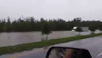 A truck driver driving through dangerously flooded road - Pegagu